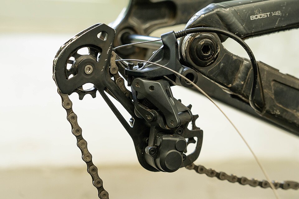 A bike chain running through the rear derailleur's two pulley wheels